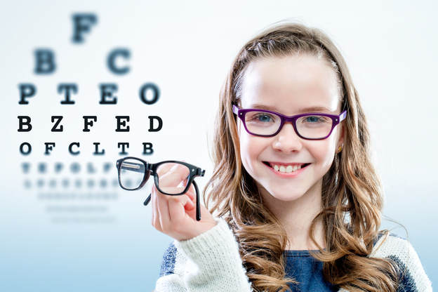 Girl wearing glasses with eye chart
